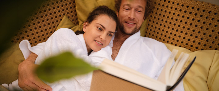 Entspannte Atmosphäre mit einem jungen Paar, was die gemeinsame Zeit auf der AIDAnova bei einem Buch genießt.